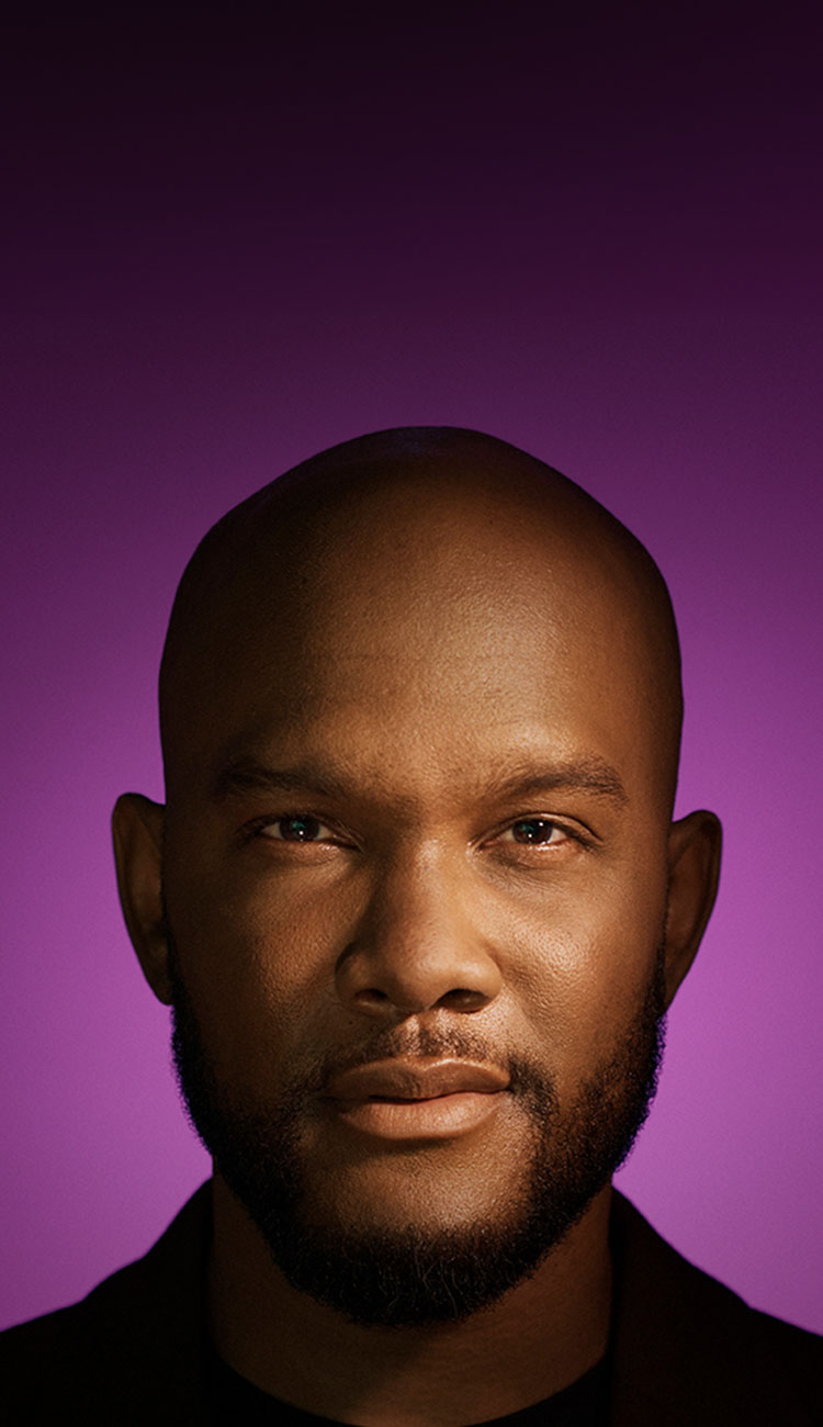 Portrait of a Black man with a beard on a purple background