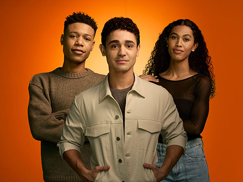 Portrait of three young people on an orange background, featuring a Black man on the left, Black woman on the right, and a Latino man in the middle.