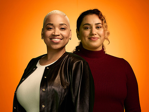 Image of a Black woman and a Latina woman on an orange background.