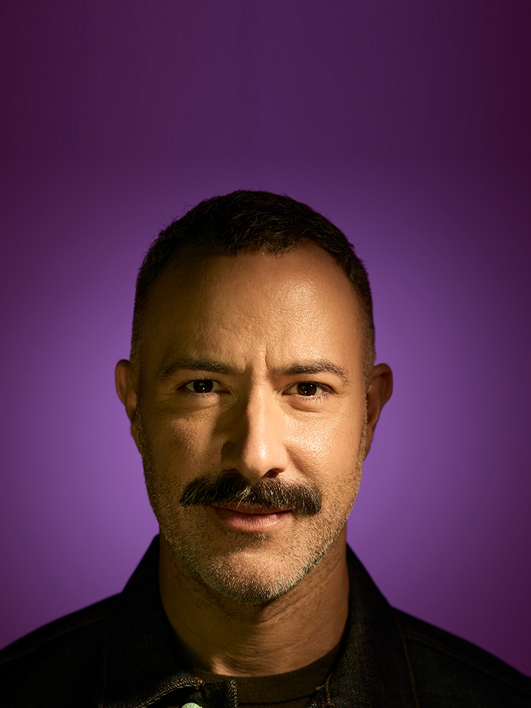 Portrait of a caucasian man with a mustache on a purple background