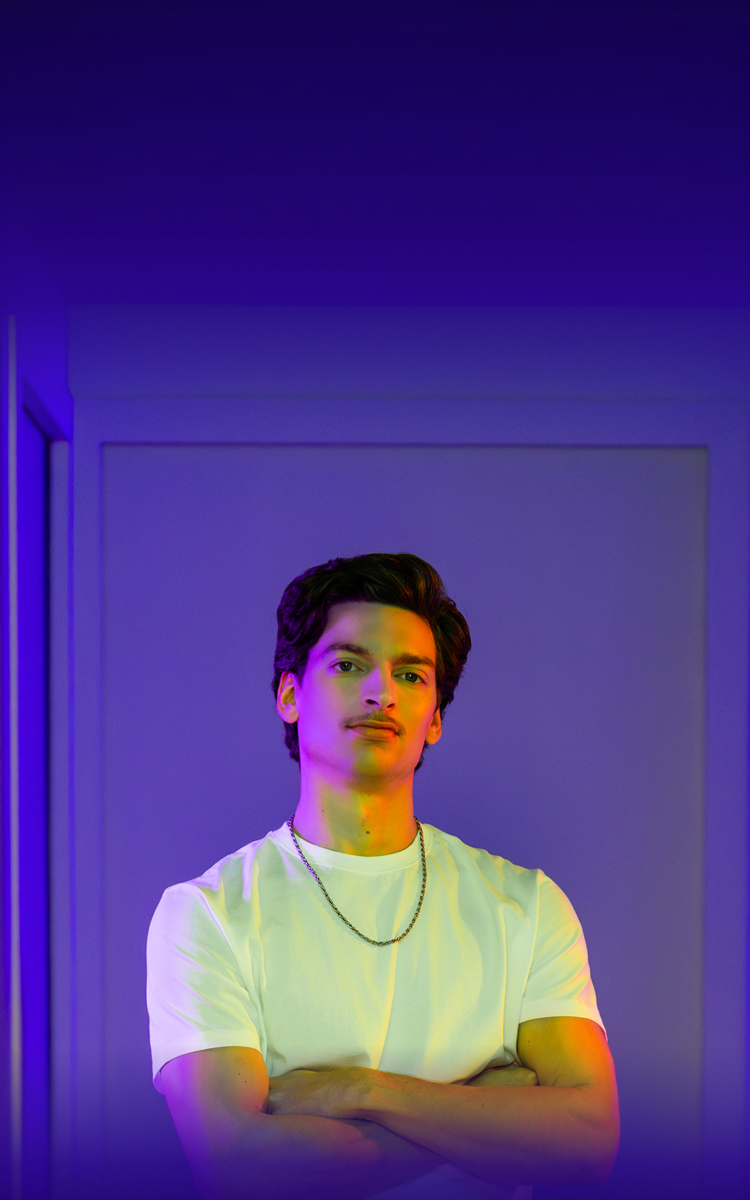 Banner image of a young Caucasian male with brown hair and a mustache wearing a white t-shirt. Not an actual patient.
